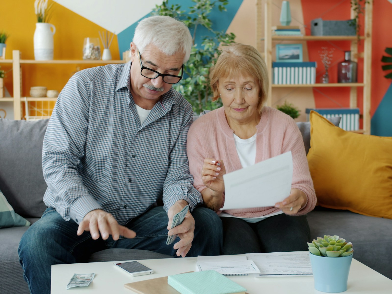 2027 Social Security COLA: a retired couple reviewing benefit statements and bills at home